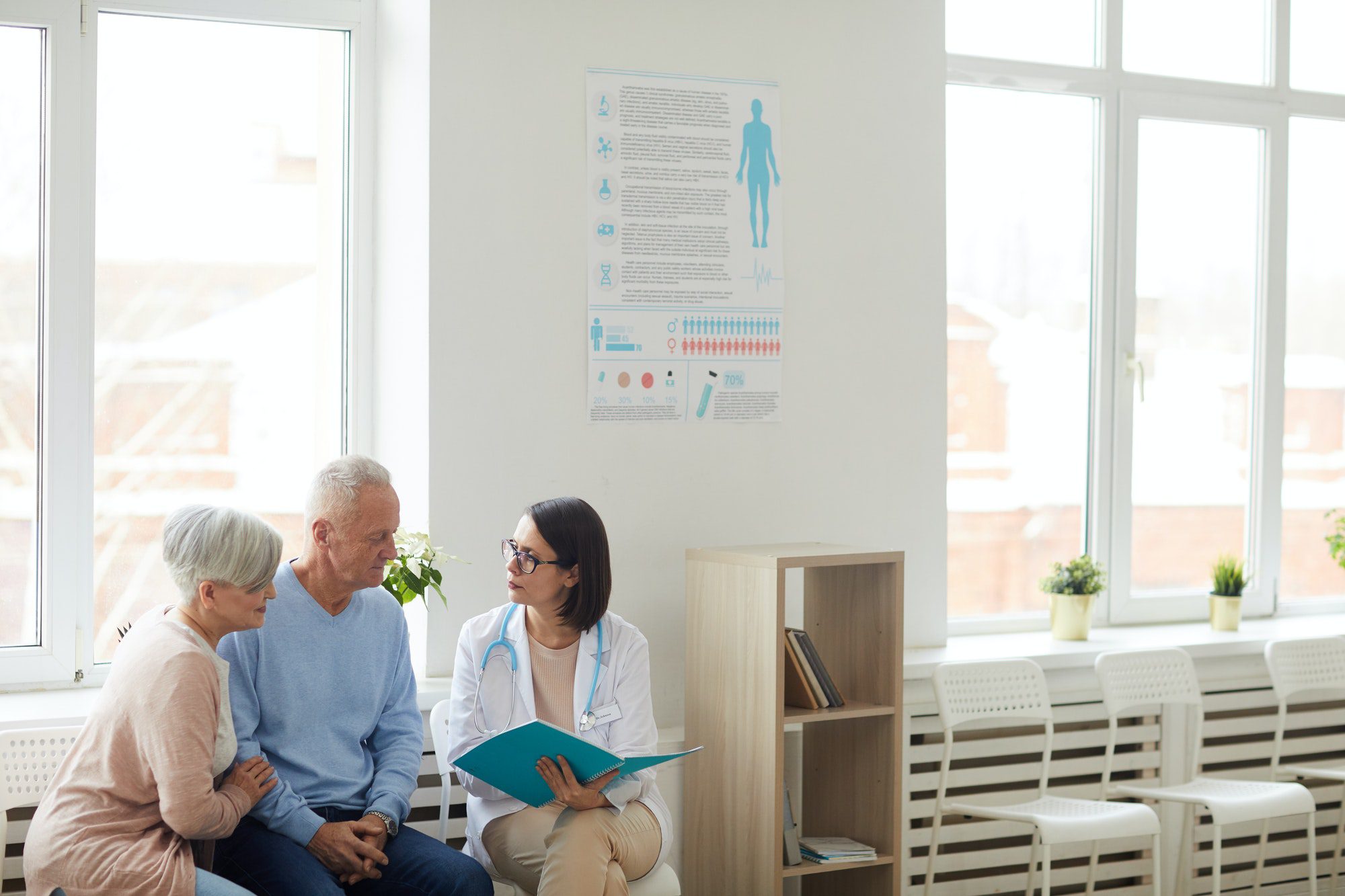 Female Doctor Registering Senior Couple Senior Couple